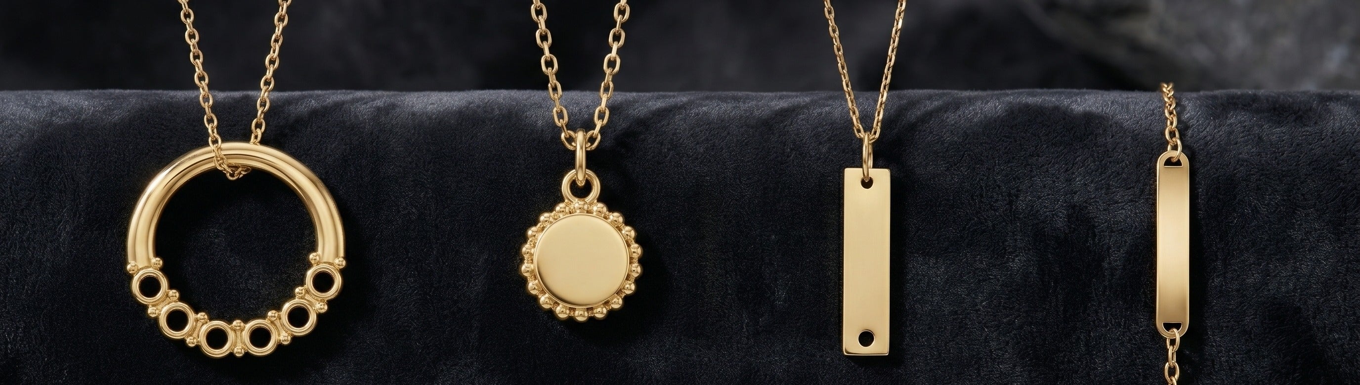 Four gold necklaces on a black background